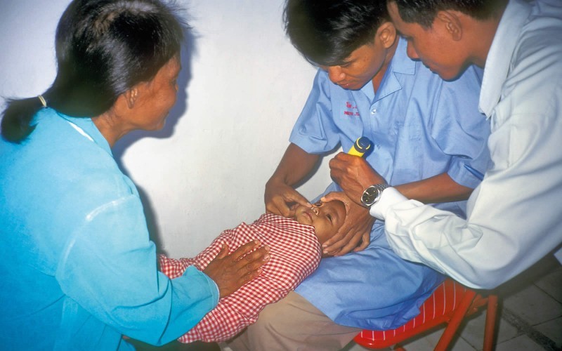 Primary health care workers examine a baby. CAMBODIA. © Sue Stevens