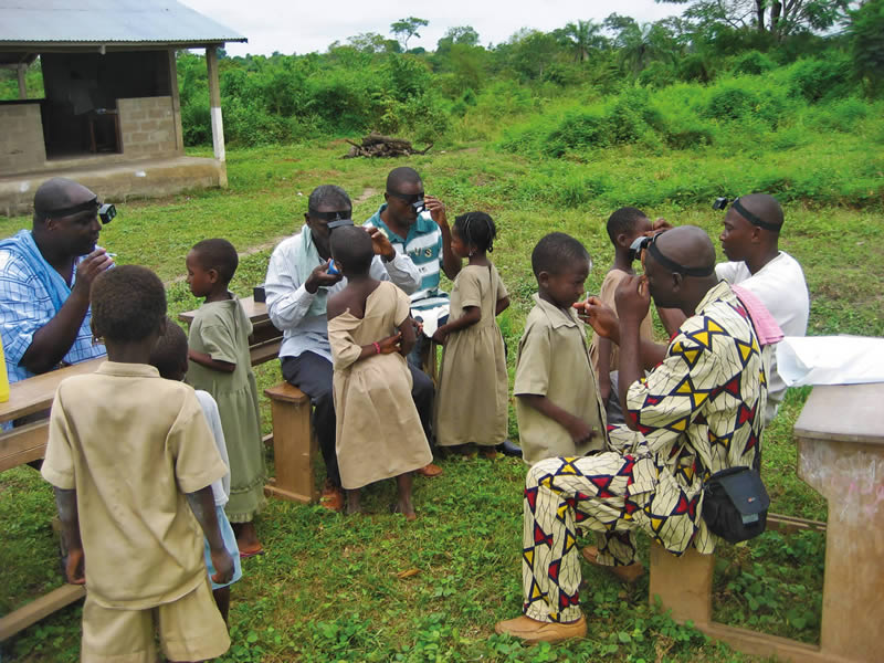 After giving stool and urine samples (to detect soil-transmitted helminths and schistosomiasis, respectively) the children are checked for signs of trachoma. TOGO © Els Mathieu