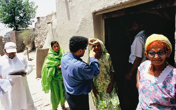 examining-eyes-door-to-door-pakistan Examining eyes door to door in a village. PAKISTAN. © Jamshyd Masud/Sightsavers.
